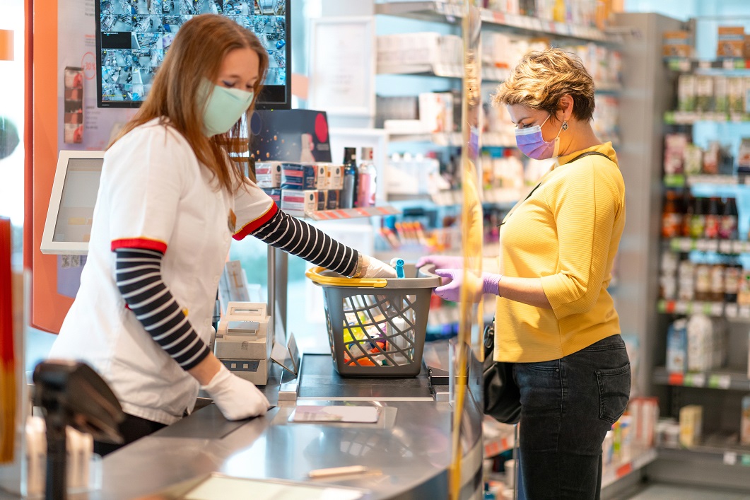 Store Clerk with Mask Checking Out Customer